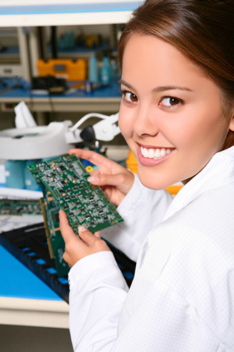 A female technician working on computer parts in a lab.