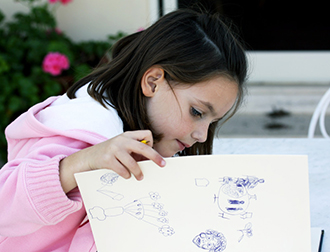 A little girl drawing a picture. 