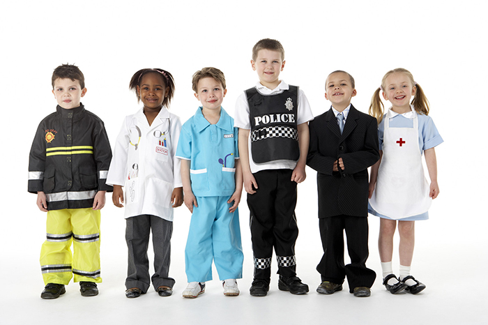 Young children dressed as different professionals such as a firemen, doctor, nurses, police, and lawyer. 