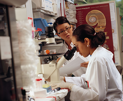 Researcher looks through microscope