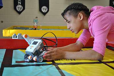 African-American girl working on robot